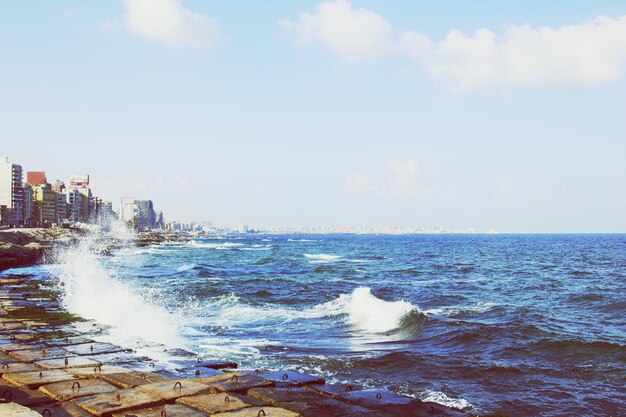 写真 海岸の岩に波が飛び散り 空に向かって