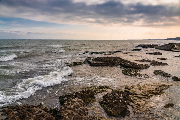 Wave splashing at the rocks, freshness on beach