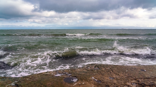 Wave splashing at the rocks, freshness on beach