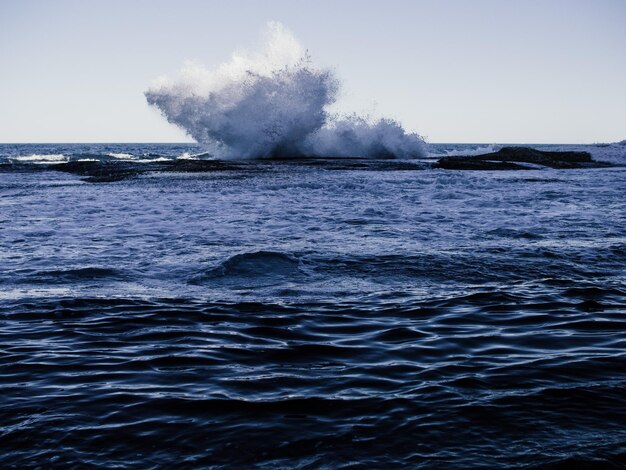 Foto le onde che schizzano sulle rocce