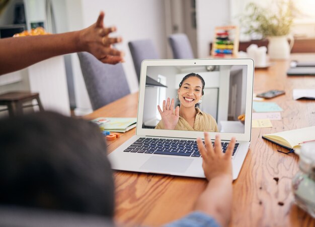 Foto wave videogesprek en kind met vrouwelijke leraar thuis met onderwijs e-learning en lesgeven live streaming hallo en welkom van een vrouwelijke professional in een webinar voor kinderen met een glimlach in een huis