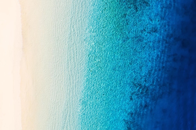 Waves as a background from top view azure water background from\
drone summer seascape from air gili meno island indonesia travel\
and vacation image