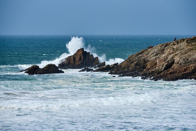 Photo waves of the atlantic ocean break on a rock with splashing gout  on quiberon in brittany in france