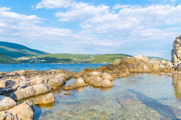 Волны разбиваются о прибрежные камни в Адриатическом море Черногория, Бока-Которский залив