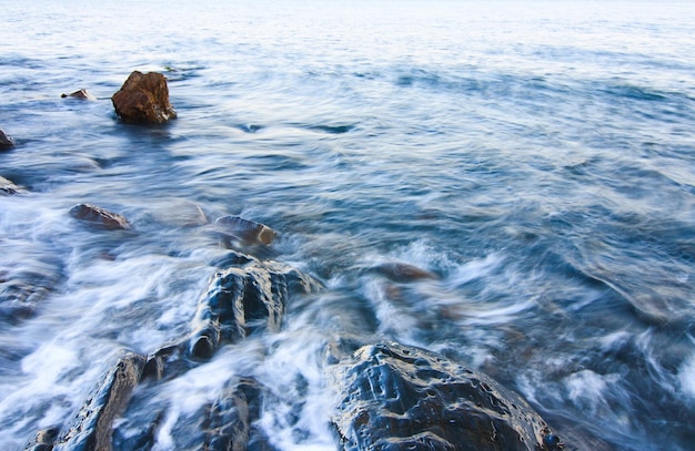 Waves breaking in the Black Sea on the rocky Bzhny coast of the Crimean peninsula on a bright sunny day Pure and wonderful nature of Crimea Ukraine territory occupied by the Russian Federation