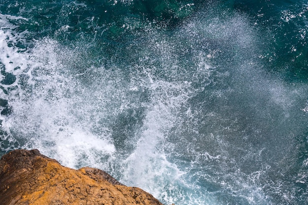 Onde che si infrangono sulla costa rocciosa vista dall'alto