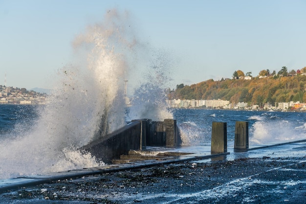 Photo waves crash onto the shore at alki beach in west seattle washington