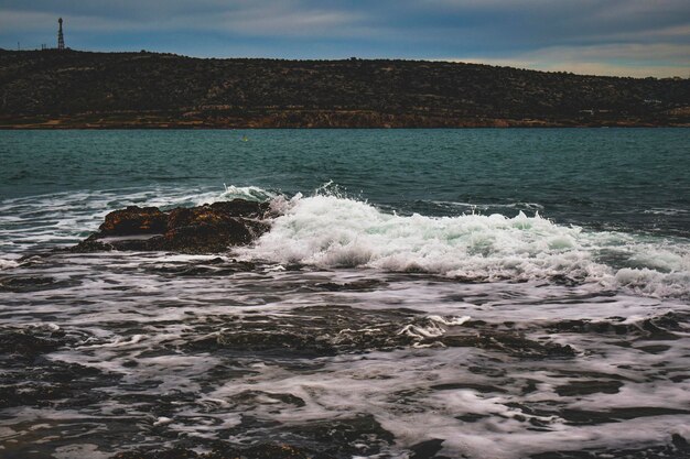 Photo waves crash with splashes on the seashore