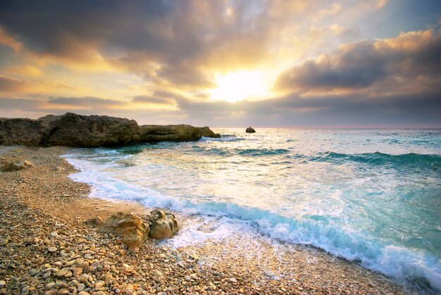 Waves crashing into the shore during sunset