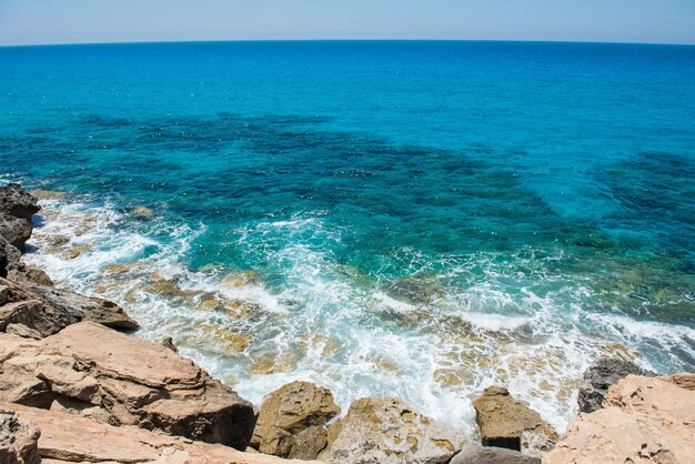 Waves crushing rocky coastline Sea and summer concept