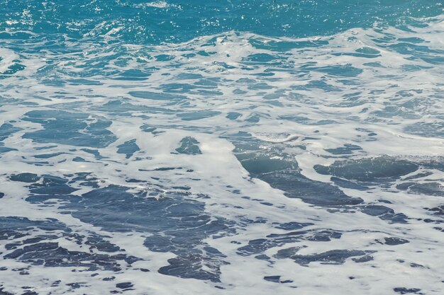 Waves and foam at the beach close-up.