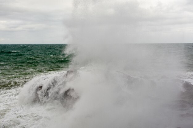 写真 大きな力で海の岩にぶつかる波