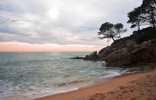 Foto onde che colpiscono le rocce del mare in un'alba in costa brava