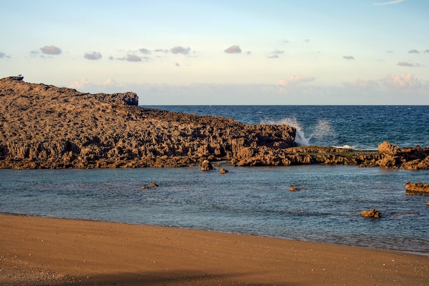 Onde che impattano su una formazione rocciosa argillosa su una spiaggia di porto rico