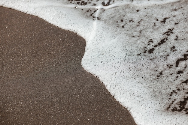 Waves lapping on the black sand