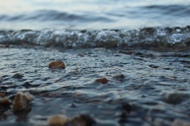 Waves on the river with colorful pebbles at the bottom