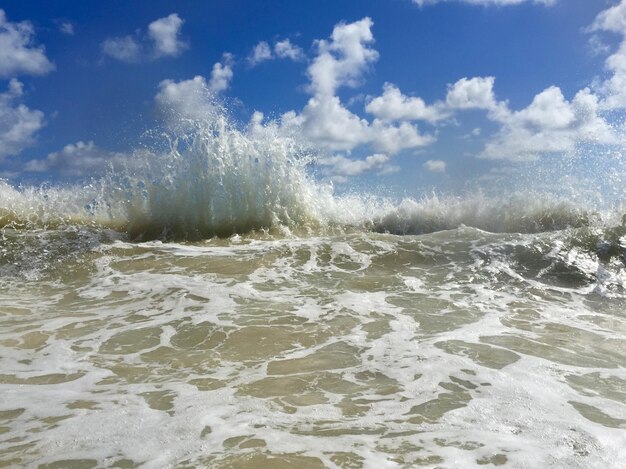 Waves in sea against blue sky