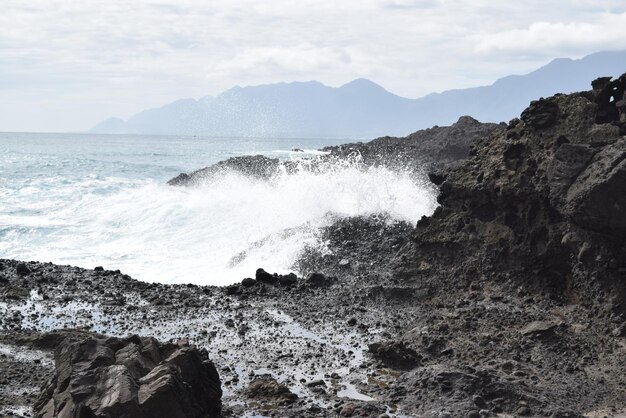 写真 岸の岩にぶつかる波