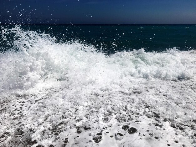 写真 海岸で波が空に飛び交う