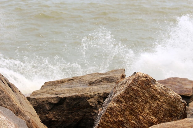 Photo waves splashing on rocks at shore