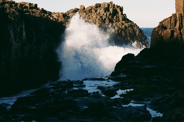 Foto le onde che schizzano sulle rocce sulla riva