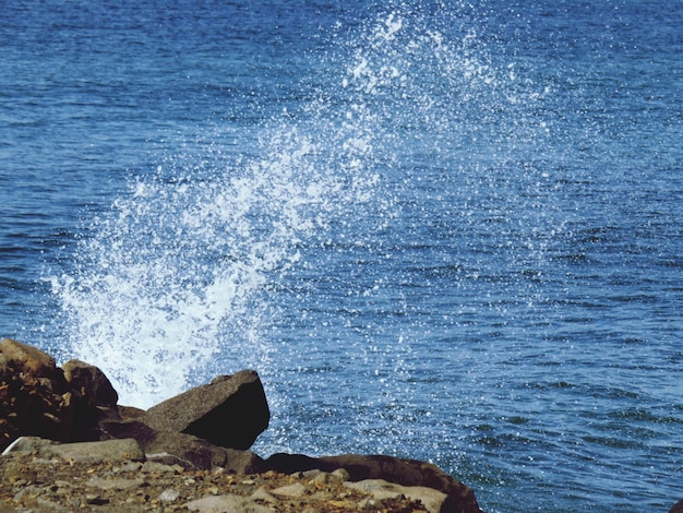 Photo waves splashing on rocks