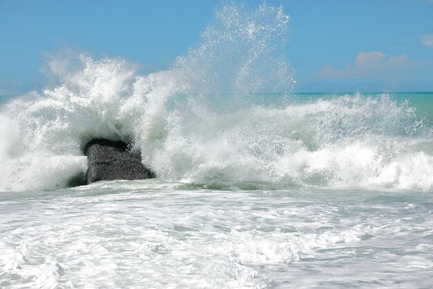 Waves splashing in sea against sky