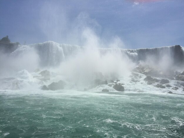 Waves splashing on sea against sky