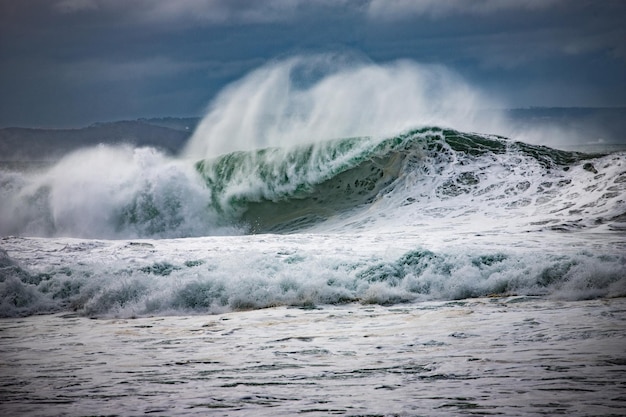waves splashing in sea against sky