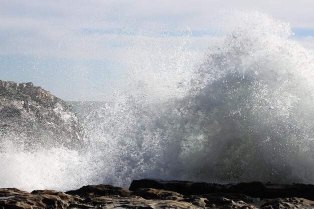 Photo waves splashing on shore against clear sky