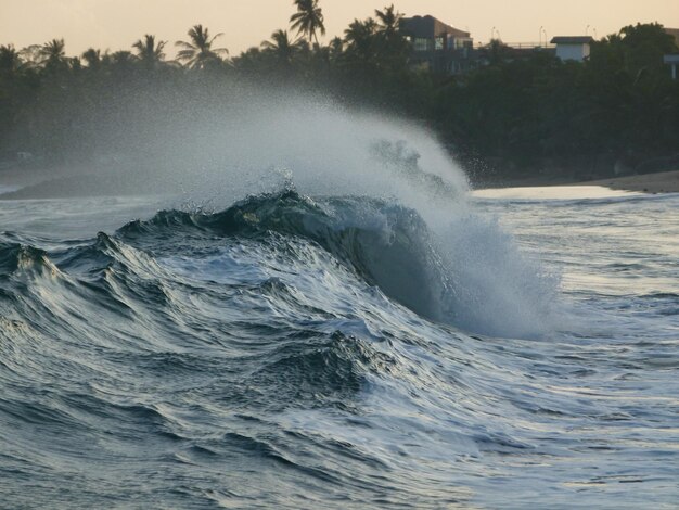 Photo waves splashing on shore against sky