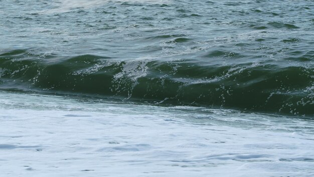 Waves swaying on sea water glassy droplets of ocean water perfect wave breaks and splashes slow