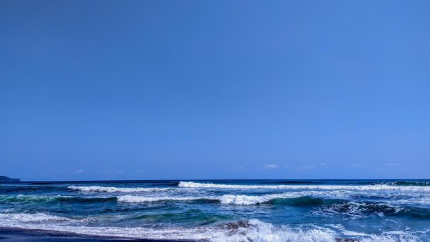 Photo waves and white foam on the beautiful coast