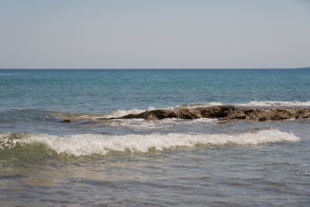 Waves with foam on Aegean sea coast in Crete Greece.