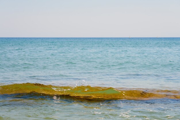 Waves with foam on Aegean sea coast in Crete Greece.