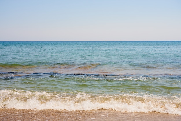 Waves with foam on Aegean sea coast in Crete Greece.