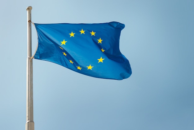 Waving European Union EU flag on the blue sky background