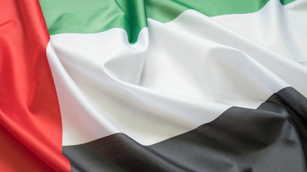 Sventolando la trama del tessuto della bandiera con il colore degli emirati arabi uniti, bandiera reale degli emirati arabi uniti