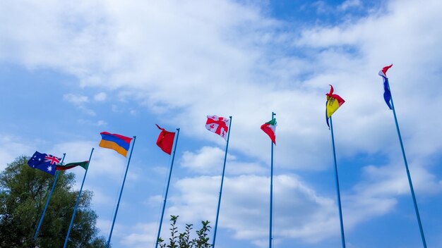 Waving flags of Australia, Armenia, China, Georgia, Iran, Romania and Sweden in the blue sky. Friendship of countries and peoples.