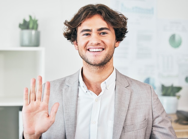 Waving greeting and friendly business man with a bright smile attending a virtual meeting or video call Portrait of a cheerful joyful and excited male employee joining an online webinar