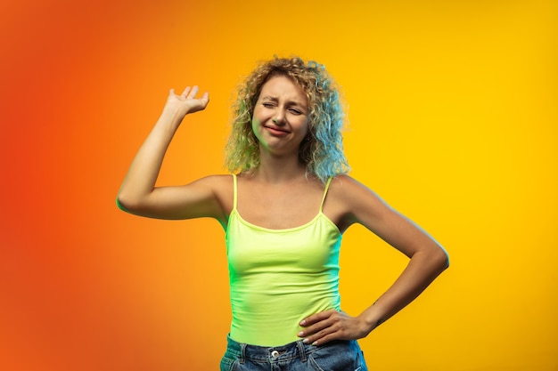 Waving hand Caucasian young womans portrait isolated on gradient studio background in neon