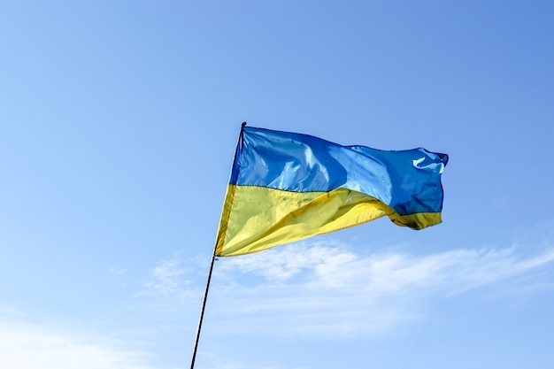 Waving Ukrainian flag against a blue sky