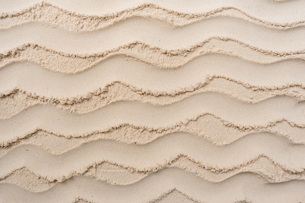 Wavy pattern on sand beach background.