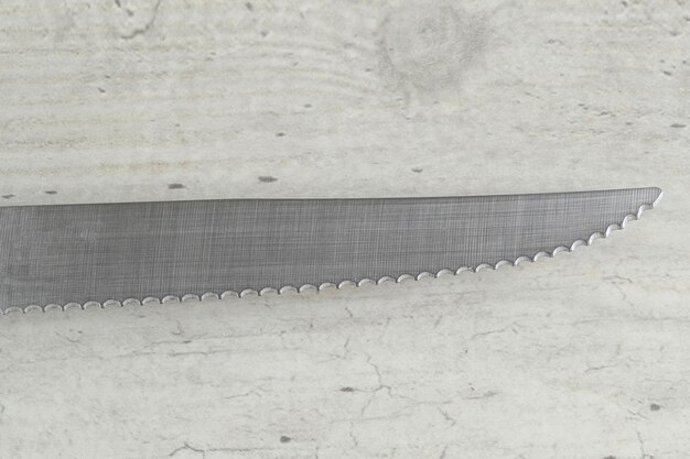 Wavy Serrated Kitchen Knife on White Table