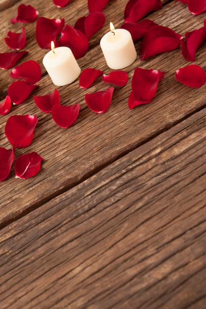 Wax candles surrounded with rose petals