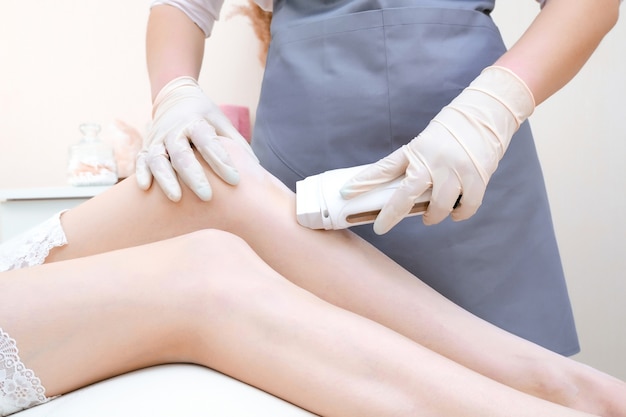 Wax depilation of legs, depilation of a young woman. Smooth skin care