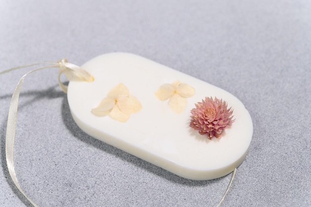 Photo wax oval sachet with dried flowers closeup on concrete gray plane product photo flat lay closeup