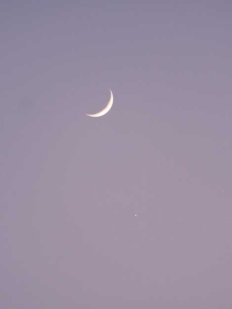 夕方の空の空に雲のない月と星が輝いている