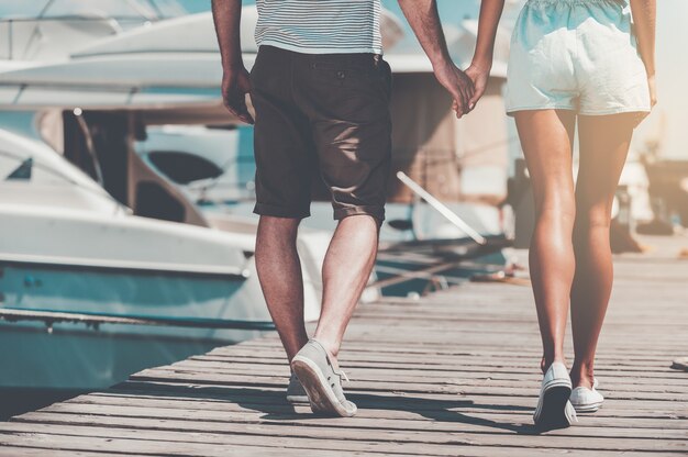 The way of true love. Close-up of young couple holding hands while walking along quay