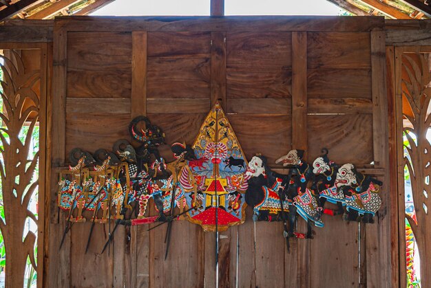 Photo wayang kulit displayed on a wooden wall indonesian and javanese traditional shadow puppets made of leather